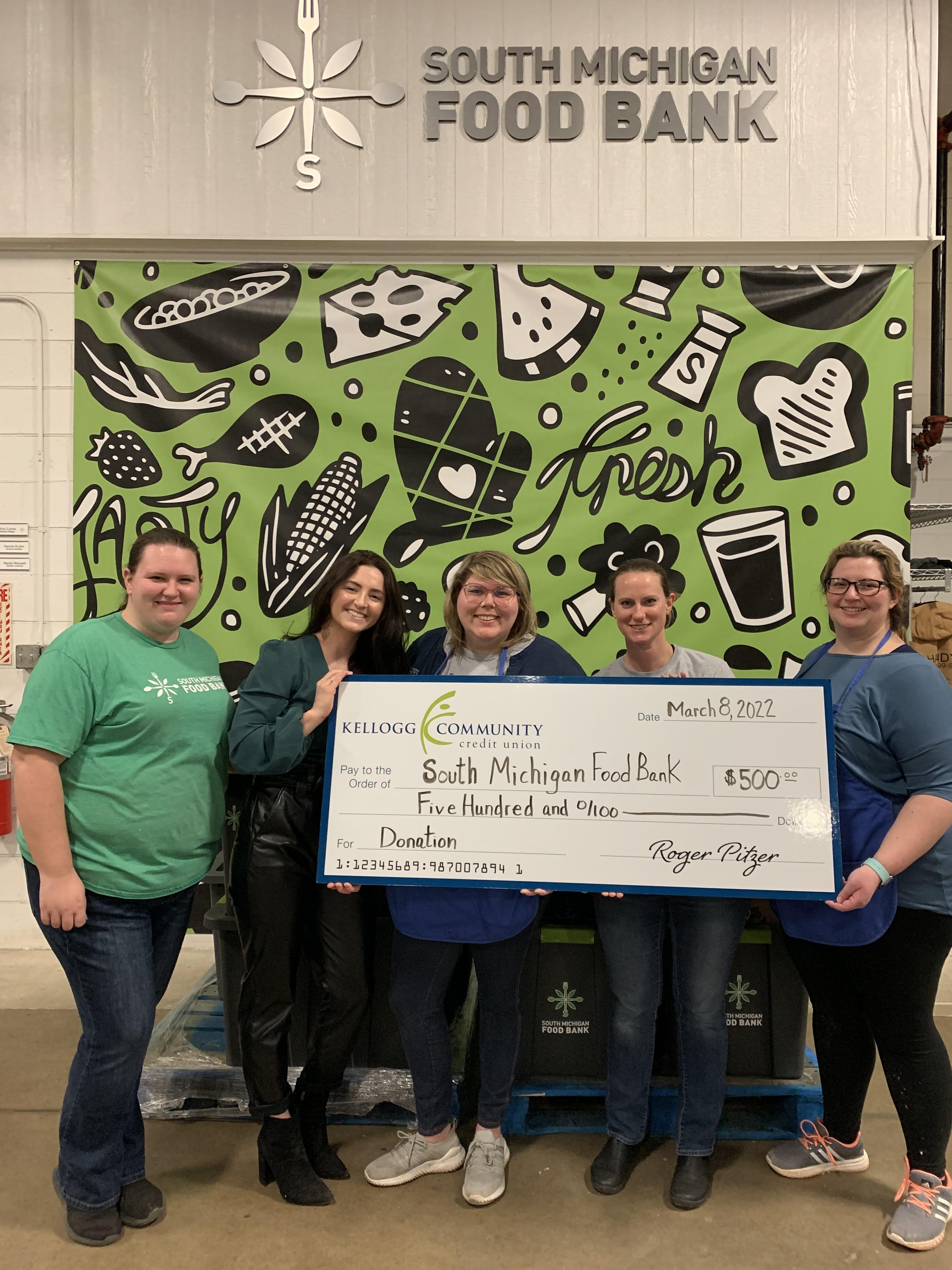 KCCU team presents donation check to South Michigan Food Bank